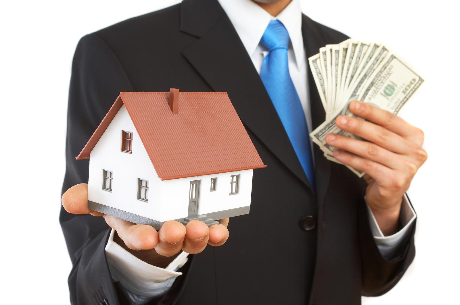 businessman with mini house and US dollars